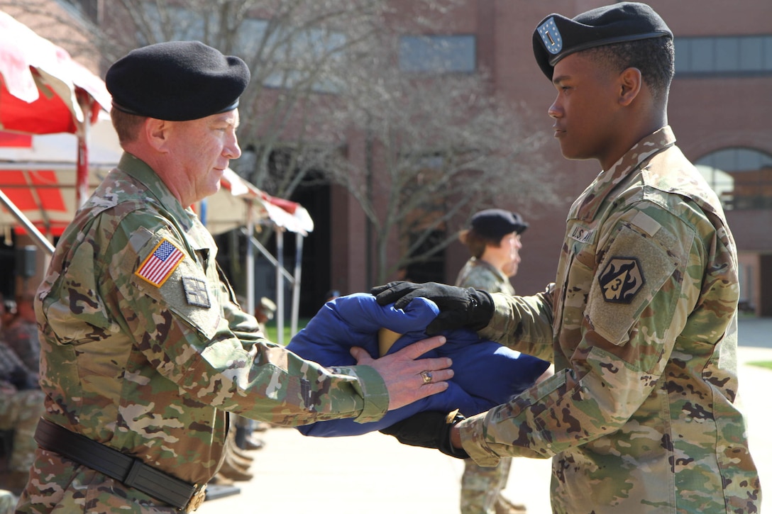 Outgoing commander of the 102nd Training Division (Maneuver Support), Brig. Gen. John Elam, (Left)accepts a canon shell casing fired in honor of his years of dedication and service during a Change of Command ceremony at Ft. Leonard Wood, Mo., March 3, 2016.  Elam, along with Command Sgt. Maj. John Stumph, handed the reins of leadership of the 102nd over to the new commander, Brig. Gen. Miyako Schanely, and Command Sgt. Maj. Robert Provost.  The 102nd trains engineers, military police, and CBRN (chemical, biological, radiological, and nuclear) soldiers across the United States.  Because soldiers from the Ozarks region initially made up the 102nd, it is historically known as "The Ozark Division" and its motto remains "Distinction, Valor, Marksmanship."