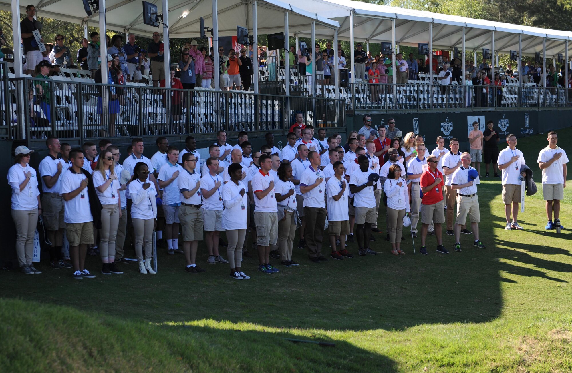 Keesler Airmen volunteers place their hand over their heart during the singing of the national anthem during the Mississippi Gulf Resort Classic closing ceremonies at the Fallen Oak Golf Course April 3, 2016. Col. Michele Edmondson, 81st Training Wing commander, and the base honor guard also participated in the festivities. (U.S. Air Force photo by Kemberly Groue)