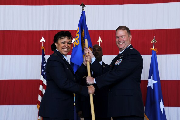 Maj. Gen. Stayce Harris, 22nd Air Force commander, passes the 302nd Airlift Wing guide on to Col. James DeVere during an assumption of command ceremony April 2, 2016, Peterson Air Force Base, Colo. DeVere comes to the 302AW from Dobbins Air Reserve Base, Ga., where he was the 94th Operations Group commander. (U.S. Air Force photo/Staff Sgt. Amber Sorsek)
