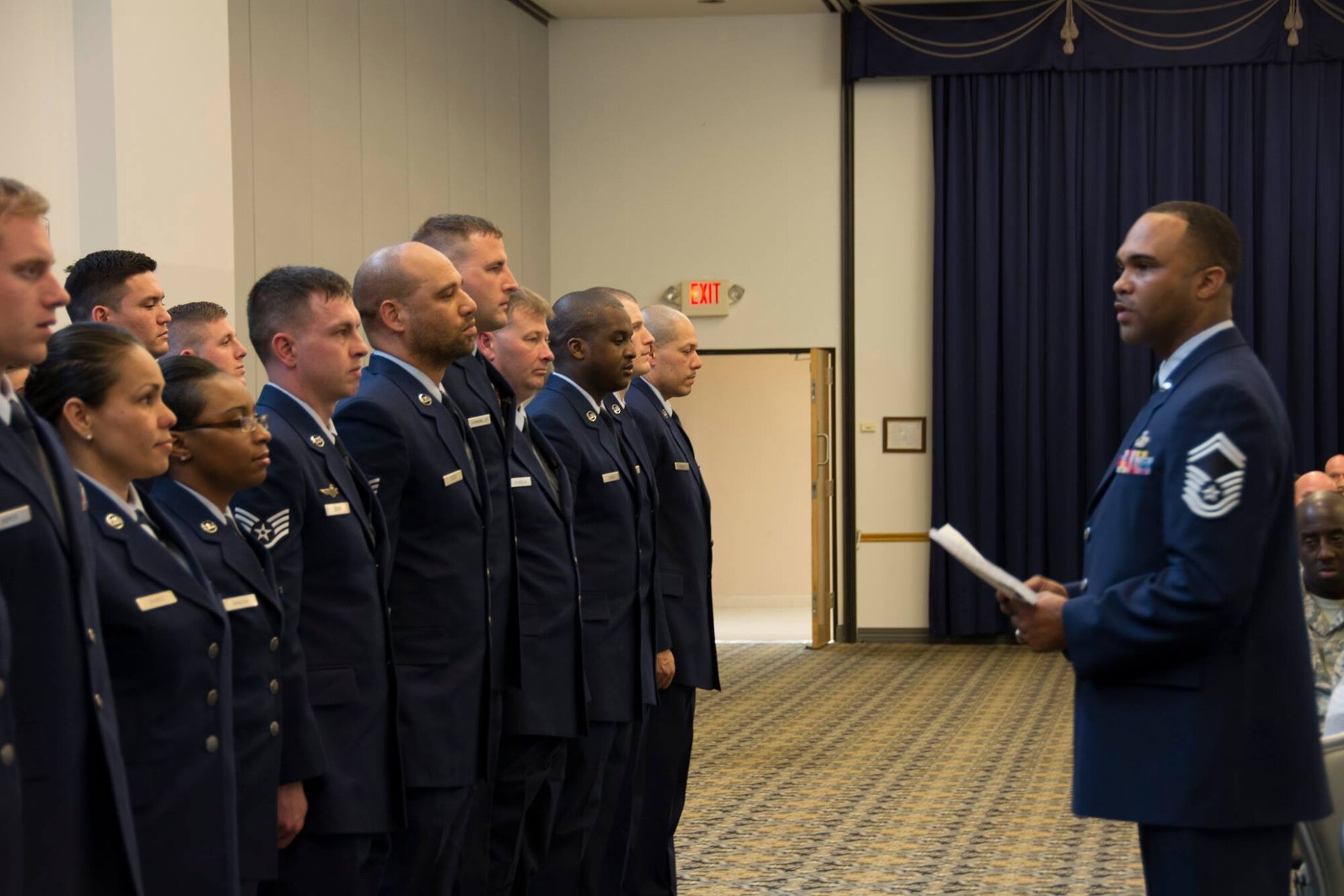 Senior Master Sgt. Anthony Harris, 512th Force Support Squadron, reads the Noncommissioned Officer Charge to almost 90 of the 512th Airlift Wing's newest staff sergeants during an NCO induction ceremony held here at Dover Air Force Base, Delaware, April 2, 2016. (U.S. Air Force photo/Tech. Sgt. Mercedes Crossland)