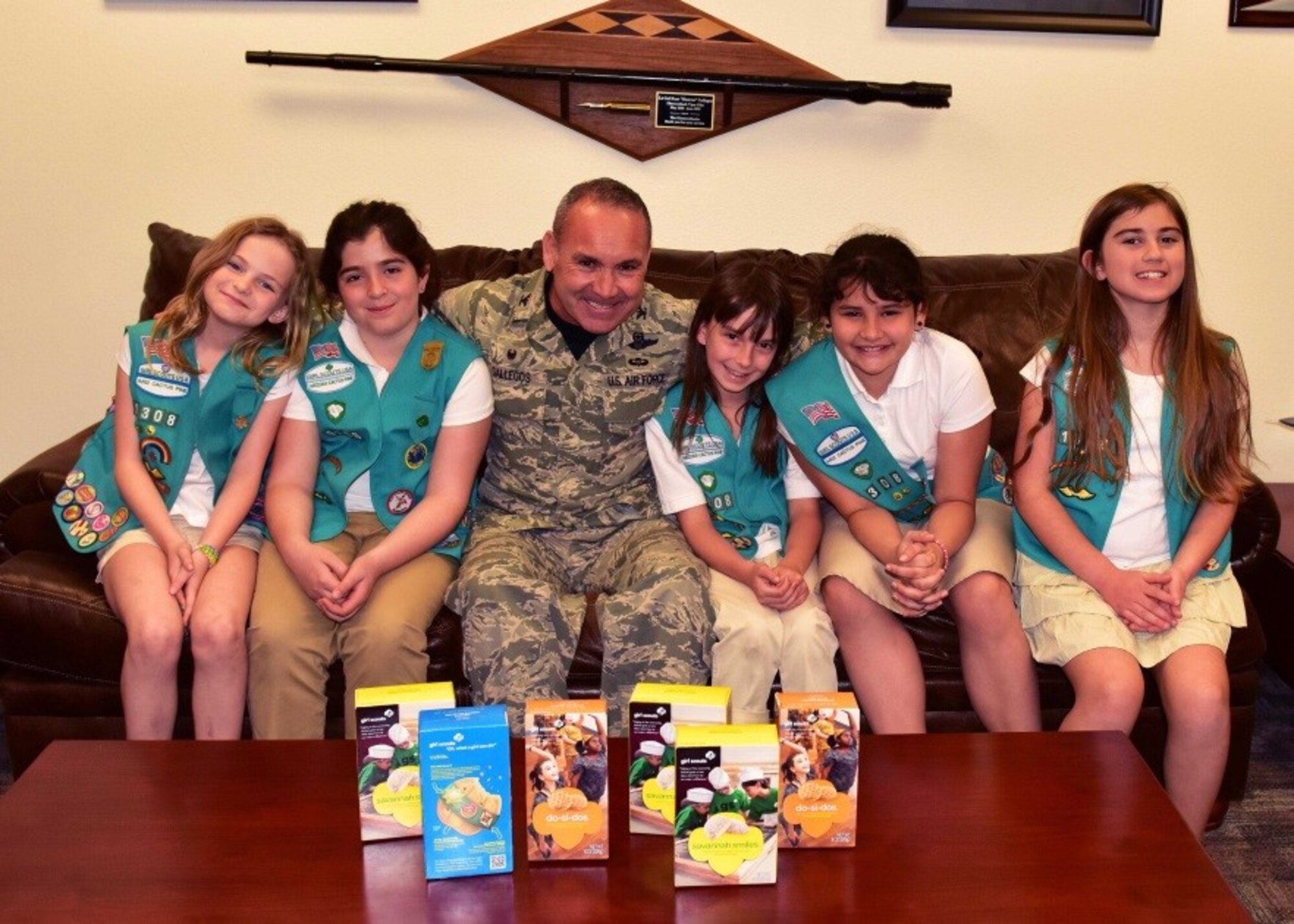 Girl Scout Troop 1308 visit and pose with Col. Kurt Gallegos, 944th Fighter Wing commander after their tour of the Wing Mar. 6. The troop delivered over 240 boxes to 944th FW Airmen. (U.S. Air Force photo by Tech. Sgt. Louis Vega Jr.)
