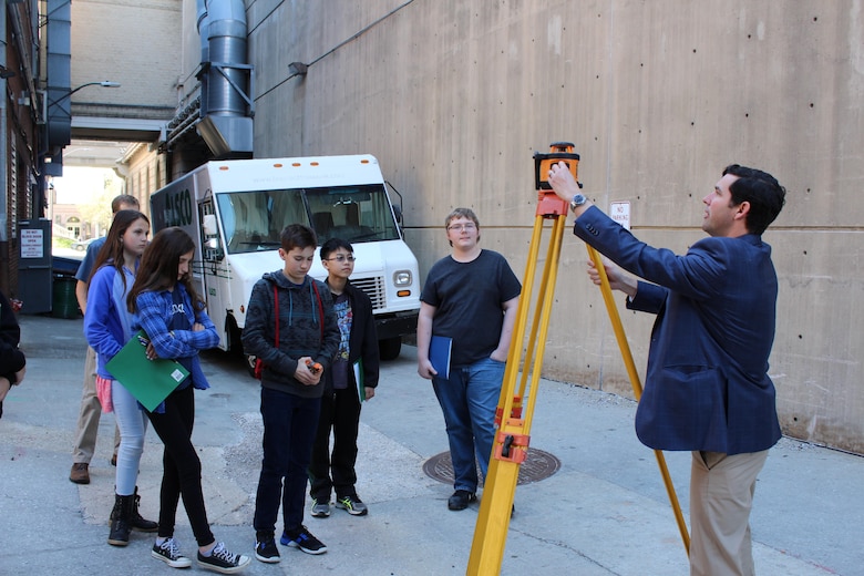 Civil engineer Blaine Linkous discusses surveying and how it plays into designing buildings with students in downtown Baltimore as part of Easy as Pi student outreach program hosted by the Baltimore Chapter of the Society of Military Engineers in downtown Baltimore Wednesday, March 30. Linkous represented his employer, Maryland-based engineering firm WBCM, which along with the U.S. Army Corps of Engineers was one of several agencies and contractors with work in Science, Technology, Engineering and Math (STEM) that participated in the event geared toward exposing students to the variety of STEM careers that exist. (U.S. Army Photo by Johnita Jackson)