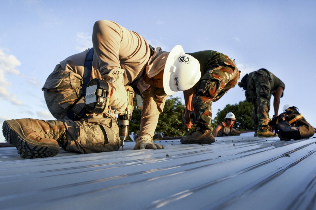 Air Force Staff Sgt. Rawlinson Satulan, left, and Philippine soldiers drill aluminum sheeting during Exercise Balikatan 2016 at an elementary school in Capiz, Philippines, April 2, 2016. Satulan is an engineer assigned to the 673rd Expeditionary Civil Engineer Squadron. Marine Corps photo by Cpl. Hilda M. Becerra
