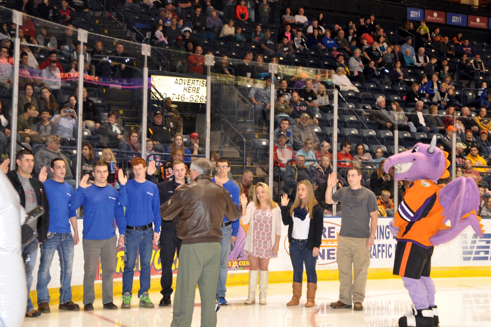 Col. Bill Phillips, commander of the 910th Operations Group, gives the oath of enlistment to some of the 910th Airlift Wing's newest members during a Youngstown Phantoms hockey game at the Covelli Centre here, April 2, 2016, while hockey fans and Phantoms mascot, Sparky, look on. A group of Citizen Airmen, based at nearby Youngstown Air Reserve Station, Ohio, participated in YARS Night Out activities before and during the game. The Phantoms, a member of the United States Hockey League, defeated the Omaha Lancers 4-1 in front of a home ice crowd of more than 3000 fans. (Courtesy Photo/Deana Barko)