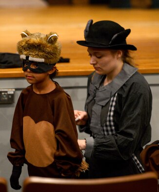Lara Dohner, Missoula Children’s Theatre tour actor-director, adjusts Alaynna Iden’s raccoon costume before a dress rehearsal for the MCT production of Red Riding Hood at the Shaw Theater at Shaw Air Force Base, S.C., April 1, 2016. Dohner and her tour partner have been traveling to a new town each week since January, providing an opportunity for children in each town to spend their free time in a creative, productive environment for a week. (U.S. Air Force photo by Senior Airman Zade Vadnais)