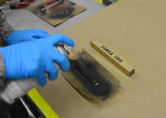 Staff Sgt. John Judy, a 436th Maintenance Squadron munitions inspector, spray paints identifying marks onto a flare stick March 28, 2016, at Dover Air Force Base, Del. All flares are assigned identifying numbers for accountability purposes. (U.S. Air Force photo/Senior Airman William Johnson)