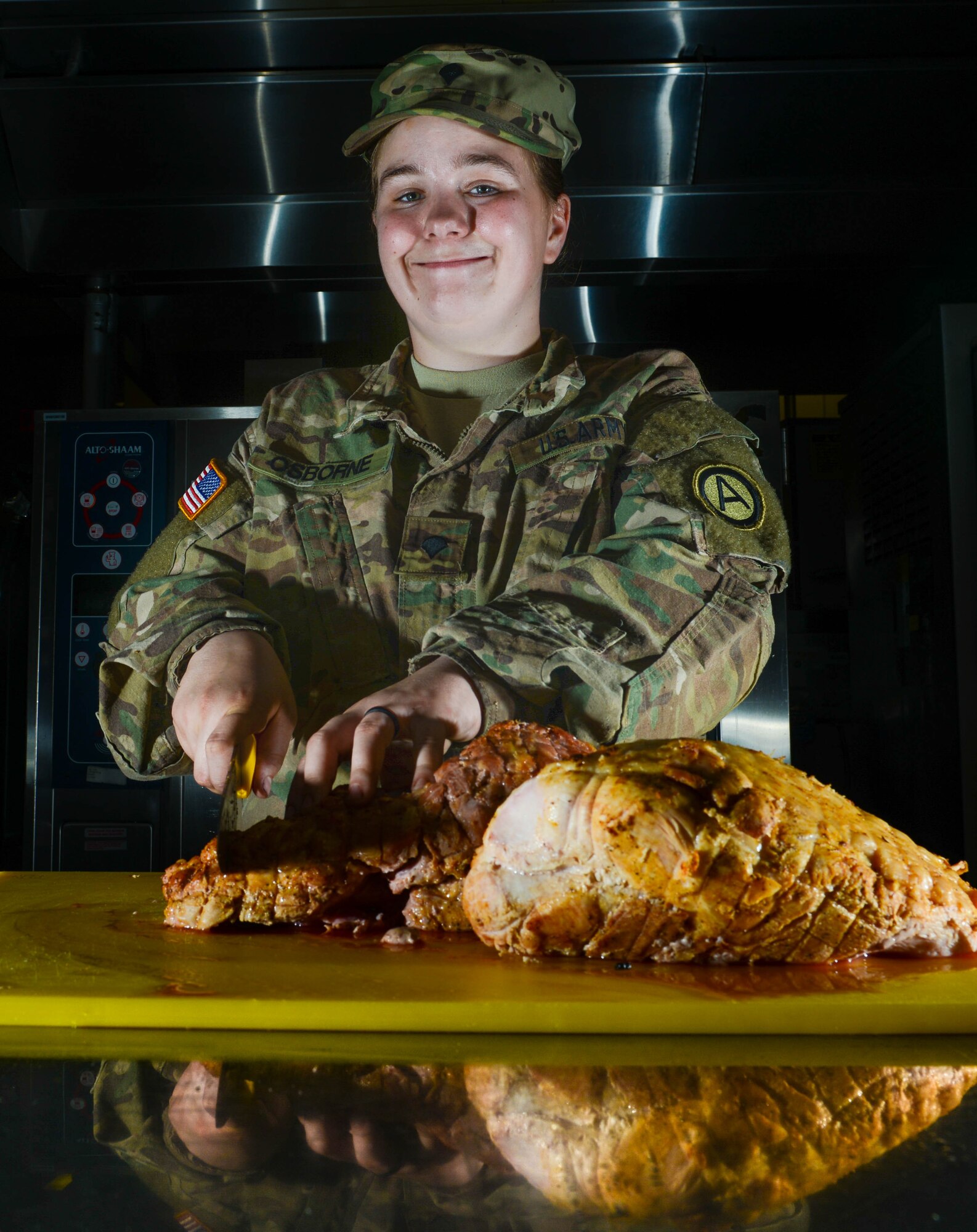 U.S. Army Spc. Angel Osborne, Army Central Command culinary specialist, cuts a turkey at Shaw Air Force Base, S.C., April 1, 2016. Osborne helps prepare meals daily for approximately 650 Airmen and Soldiers at the Chief Master Sgt. Emerson E. Williams Dining Facility. (U.S. Air Force photo by Airman 1st Class Destinee Dougherty)