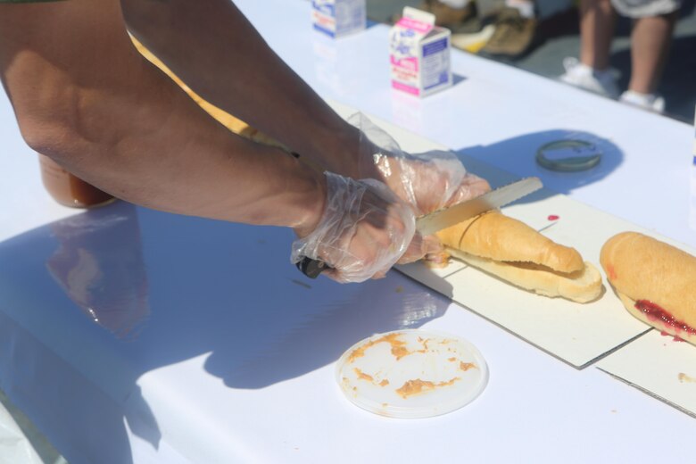 A Marine with Marine Corps Air Station Miramar’s Single Marine Program cuts a sandwich during the Stem-to-Stern PB & J challenge aboard the USS Midway Museum in San Diego, Calif., April 2, 2016. The Marines competed with 20 local Sailors to make the world’s longest peanut butter and jelly sandwich made on a military vessel.