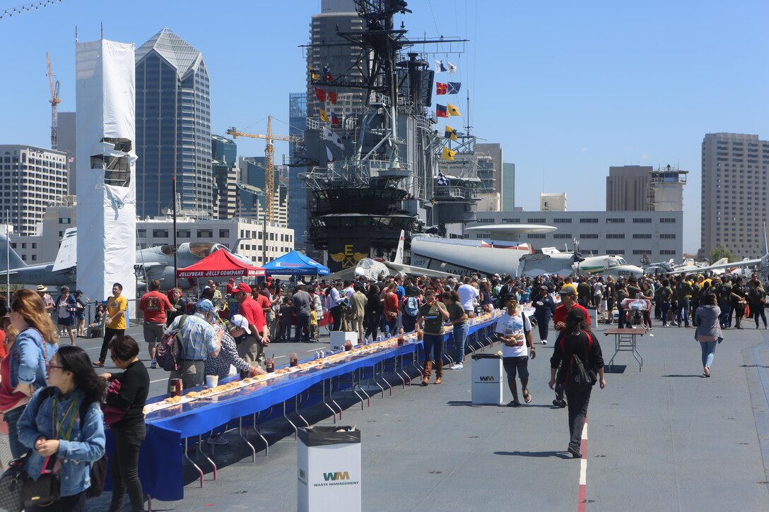 Service members, employees and members of the San Diego community enjoy a peanut butter and jelly sandwich made during the Stem-to-Stern PB & J challenge aboard USS Midway Museum in San Diego, Calif., April 2, 2016. Twenty Marines stationed at Marine Corps Air Station Miramar, Calif., competed with 20 local Sailors to build the world’s largest peanut butter and jelly sandwich made on a military vessel.