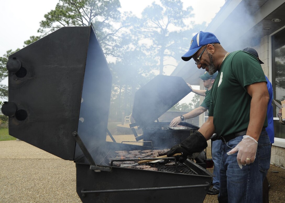 Michael Farley, 325th Mission Support Group resource advisor, grills food for members of Team Tyndall April 1, 2016, at the Heritage Club during a Comprehensive Airmen Fitness Day luncheon. Comprehensive Airmen Fitness Days serves as a time to talk about the four pillars of resiliency: mental, physical, social, and spiritual. (U.S. Air Force photo by Senior Airman Solomon Cook/Released)