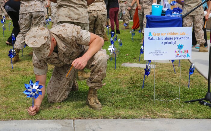 A Marine from Marine Corps Recruit Depot San Diego places a pinwheel in a garden area behind the Marine Corps Exchange during a Pinwheels for Prevention event here, April 5. This event brings recognition to supporting the healthy development of children nationwide.