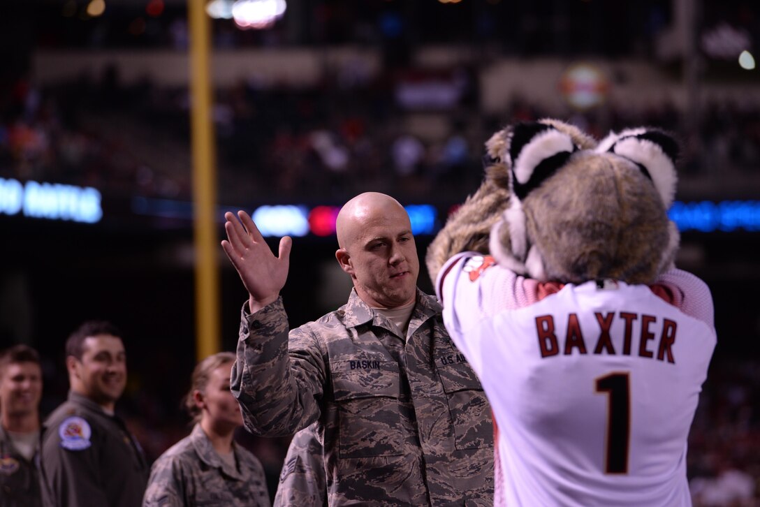 Staff Sgt. Derek Baskin, 62nd Fighter Squadron aircrew flight equipment technician, smiles after giving Baxter, the Arizona Diamondbacks’ mascot, a high-five during the Diamondbacks’ season opener on April 4th, 2016 at Chase Field ballpark in Phoenix, Ariz. Baskin was part of a crew of 62nd FS Airmen who ensured the successful performance of an F-35 flyover just before the start of the game. (U.S. Air Force photo by Airman 1st Class Ridge Shan)