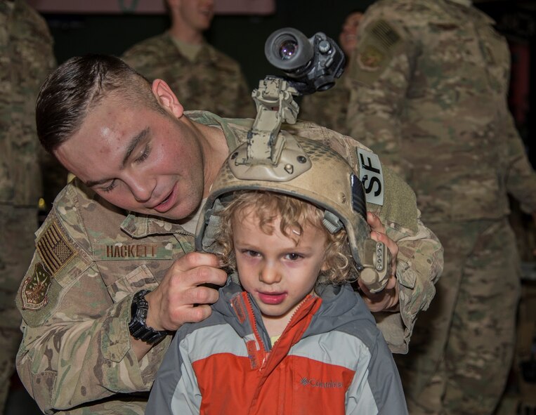 Airman 1st Class Travis Hackett, 791st Missile Security Forces Squadron tactical response force member, demonstrates a TRF helmet with a Minot Youth Center member at Minot Air Force Base, N.D., March 25, 2016. The 91st MSFS TRF held a display at the event to educate participating youth. (U.S. Air Force photo/Airman 1st Class Christian Sullivan)