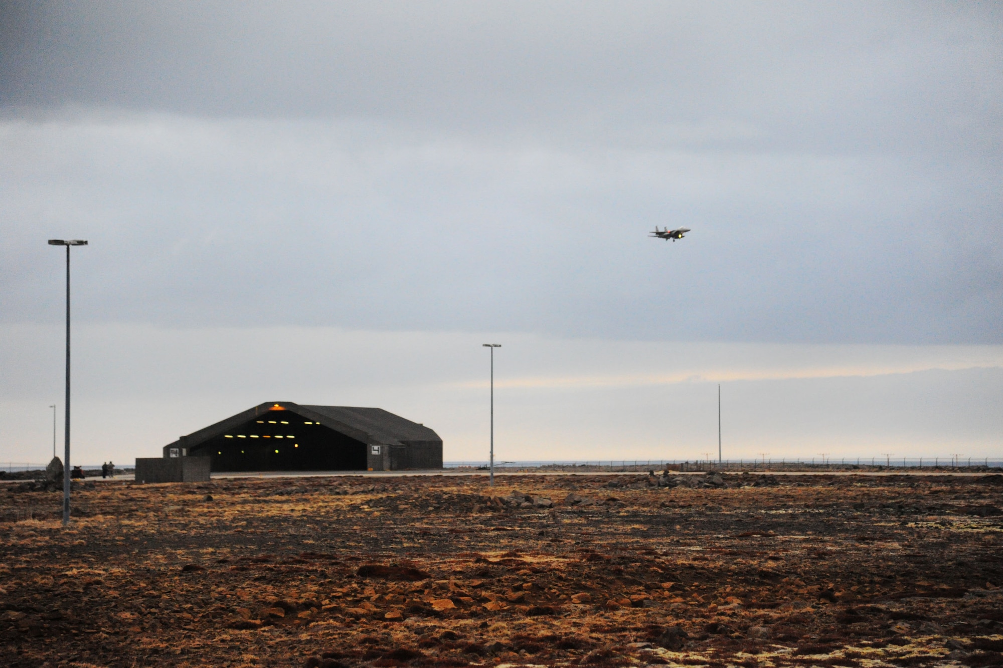 A U.S. Air Force F-15C Eagle fighter aircraft assigned to the 131st Fighter Squadron, 104th Fighter Wing, Barnes Air National Guard Base, Mass., circles past the hardened aircraft shelters prior to landing at Keflavik International Airport, Iceland, April 3, 2016. Four F-15Cs and approximately 200 Airmen deployed in support of Icelandic Air Surveillance operations from April 1-28, 2016. (U.S. Air Force photo by Master Sgt. Kevin Nichols/Released) 