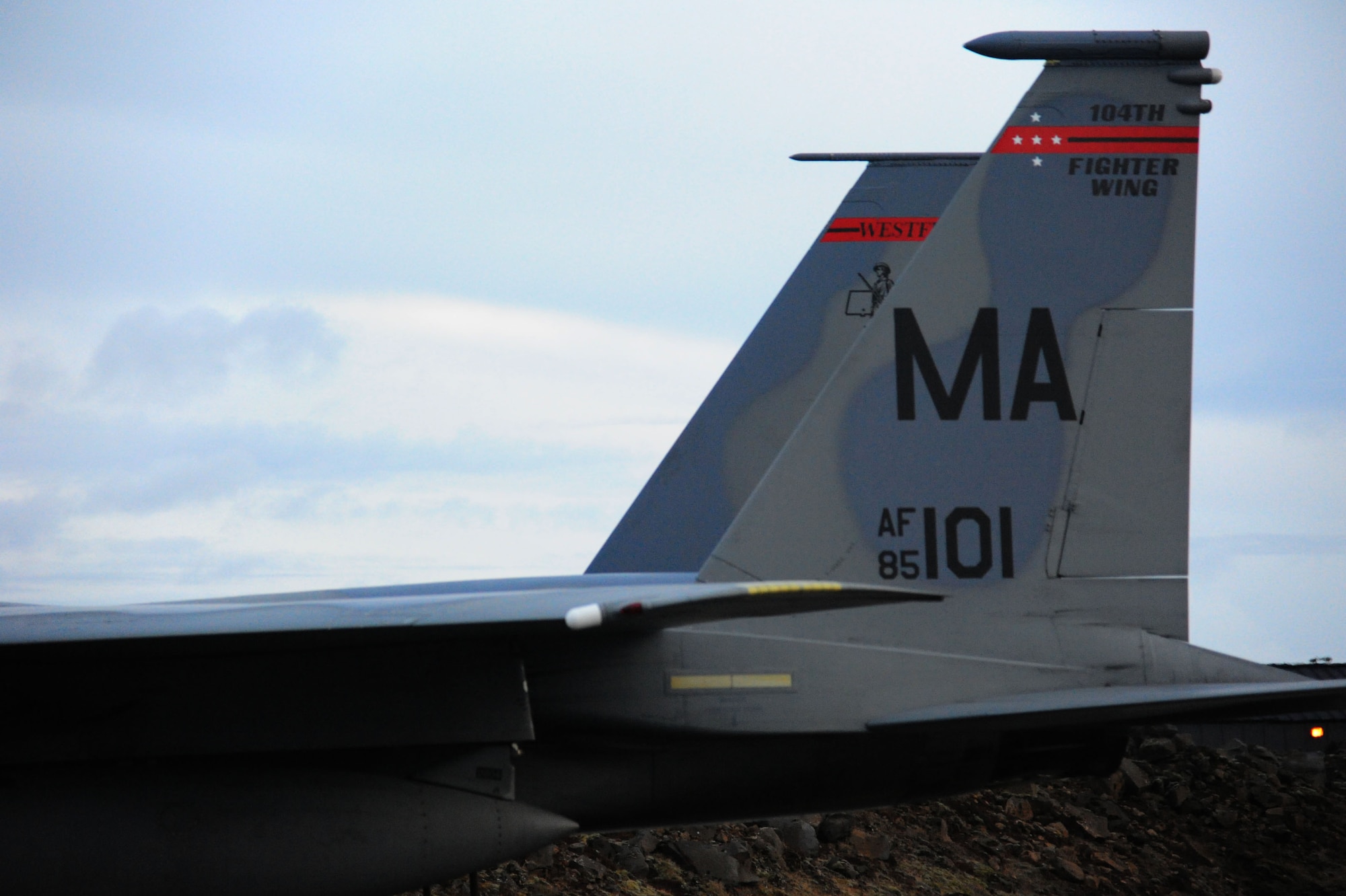 The tail of a U.S. Air Force F-15C Eagle fighter aircraft assigned to the 131st Fighter Squadron, Barnes Air National Guard Base, Mass., sits in front of a hardened aircraft shelter upon arriving at Keflavik International Airport, Iceland, April 3, 2016. The 131st FS will support Icelandic Air Surveillance operations while strengthening the U.S.-Icelandic partnership and their commitment toward regional security. (U.S. Air Force photo by Master Sgt. Kevin Nichols/Released)