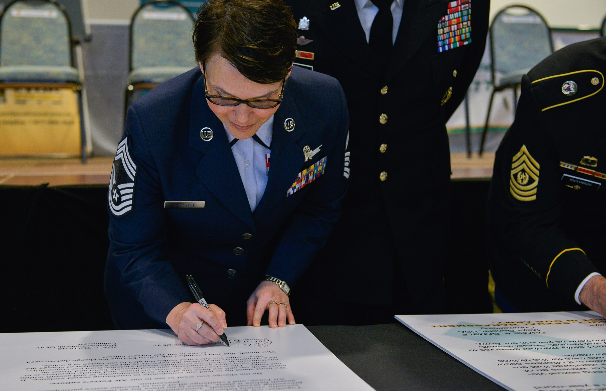 Chief Master Sgt. Amber Mitchell, 86th Operations Group superintendent, signs her name on the official Sexual Assault Resource Center opening ceremony proclamation April 1, 2016, at Ramstein Air Base, Germany. The ceremony kicked off this year’s Sexual Assault Awareness and Prevention month by having U.S Air Forces in Europe leaders sign its proclamation. (U.S. Air force photo/Airman 1st Class Lane T. Plummer)