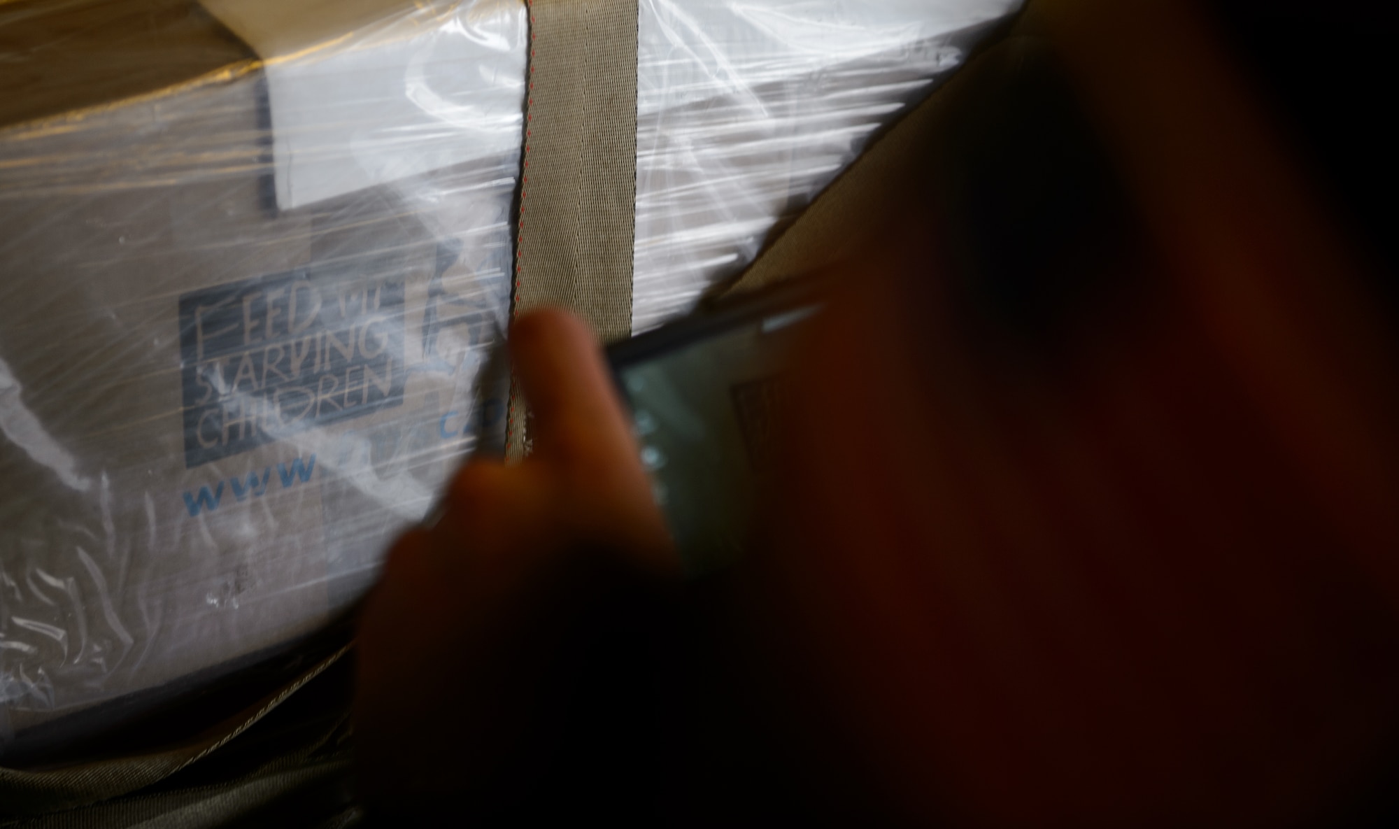 An Airman takes a photo of cargo enroute to Afghanistan at Ramstein Air Base, Germany March 25, 2016. Ramstein helped coordinated the movement of more than 285,000 meals for children in need as they transitioned from the U.S. to their final location. (U.S. Air Force photo/Staff Sgt. Armando A. Schwier-Morales)