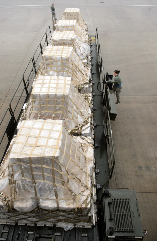 Airmen from the 721st Aerial Port Squadron move humanitarian cargo March 25, 2016, at Ramstein Air Base, Germany. A KC-10 Extender from the 76th Air Refueling Squadron brought the cargo to Germany as part of a training mission they were doing. Once at Ramstein, 721st APS Airmen will coordinate to get more than 285,000 meals to children in need. (U.S. Air Force photo/Staff Sgt. Armando A. Schwier-Morales)