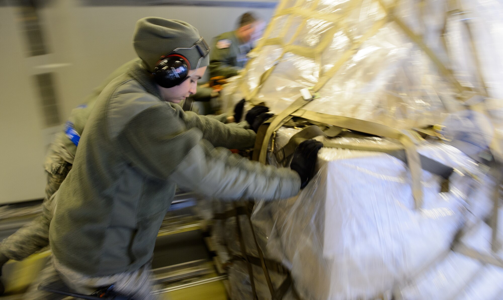 Senior Airman Caitlin Emery, 721st Aerial Port Squadron ramp services specialist, and Airmen from the 721st unload cargo March 25, 2016, Ramstein Air Base, Germany. The cargo is part of the Denton program designed to move humanitarian cargo on a space-available status. (U.S. Air Force photo/Staff Sgt. Armando A. Schwier-Morales) 