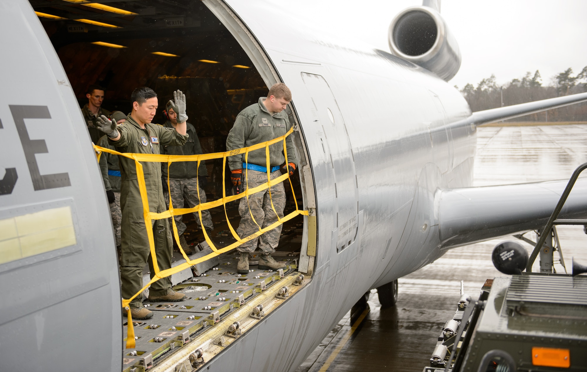 Airmen from the 721st Aerial Port Squadron and 76th Air Refueling Squadron move a cargo off-loading vehicle in to place at Ramstein Air Base, Germany, March 25, 2016. The cargo the Airmen moved was not a normal load as it was part of a humanitarian airlift proving more than 285,000 meals to children in Afghanistan. (U.S. Air Force photo/Staff Sgt. Armando A. Schwier-Morales)