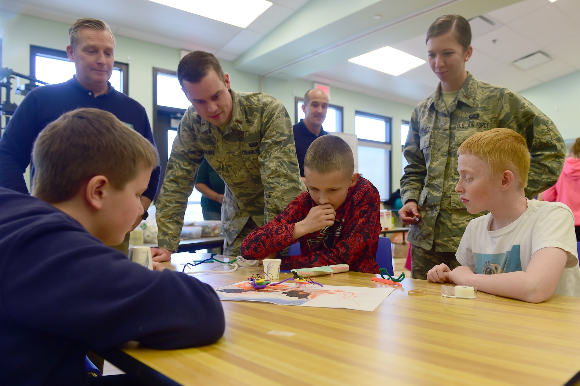 Judges ask children to explain their design during a STEM (Science, Technology, Engineering and Math) Camp project March 31, 2016, at the youth center on Buckley Air Force Base, Colo. The children were tasked with building a structure that could keep a simulated oil spill contained. (U.S. Air Force photo by Airman 1st Class Luke W. Nowakowski/Released)
