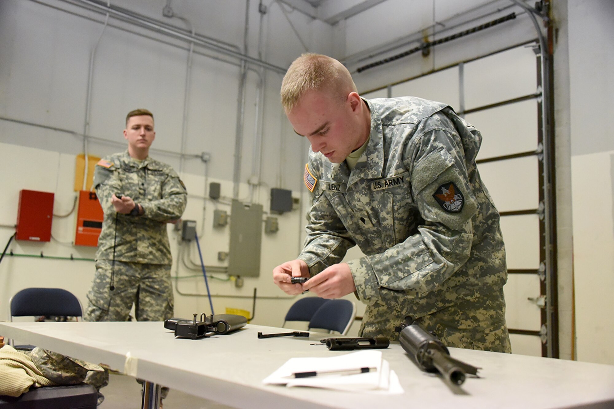 FORT MEADE, Md. – Spc. Devon Lenz, Company B, 53rd Signal Battalion, disassembles an M16A2 March 24 during the U.S. Army Space and Missile Defense Command/Army Forces Strategic Command’s Eastern Region Best Warrior Competition, March 21-24 at Fort Meade, Maryland, while Spc. Robert O’Leary times him. Lenz was named the Eastern Region’s Soldier Best Warrior. (Photos by Carrie E. David )
