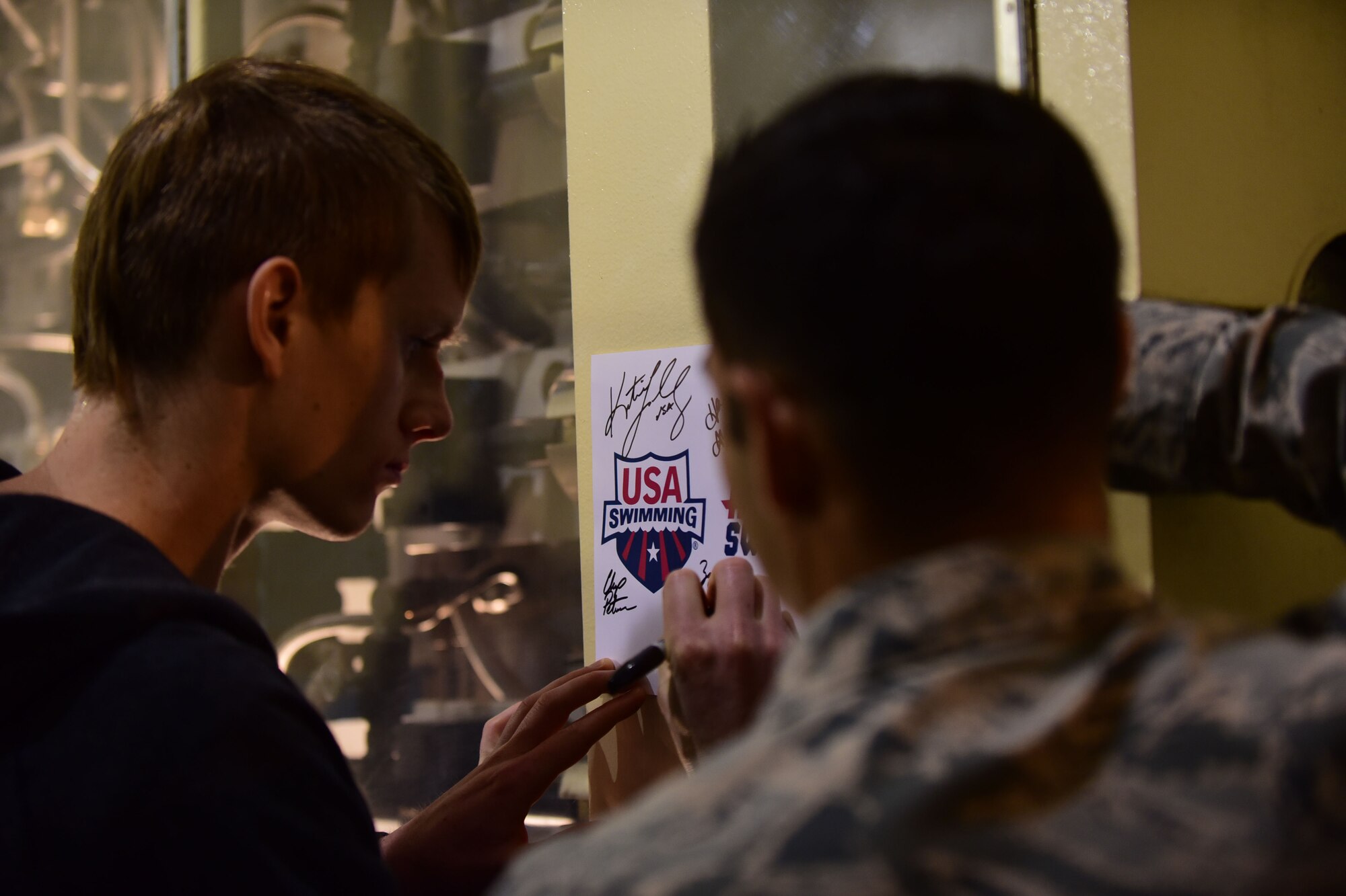 CHEYENNE MOUNTAIN AIR FORCE STATION – A member of the U.S. National Swim Team signs an autograph for an Airmen here March 30, 2016. The Team visited the Mountain as part of the ongoing 50th Anniversary celebration for CMAFS. The installation was declared fully operational April 20, 1966. (U.S. Air Force photo by Staff Sgt. Amber Grimm)