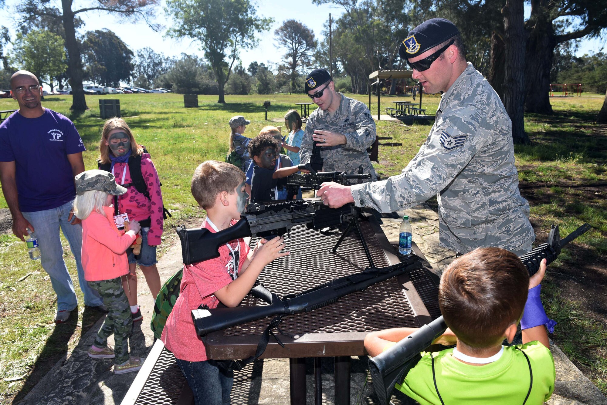 Staff Sgts. Jeremy Rhodes and Jason Blunt, 30th Security Forces combat arms specialists, demonstrate weapons during Kids Understanding Deployment Operations, March 29, 2016, Vandenberg Air Force Base, Calif. KUDOS is a program developed to give children a deeper understanding of the military deployment process and equipment utilized during a deployment. (U.S. Air Force photo by Staff Sgt. Jim Araos/Released)