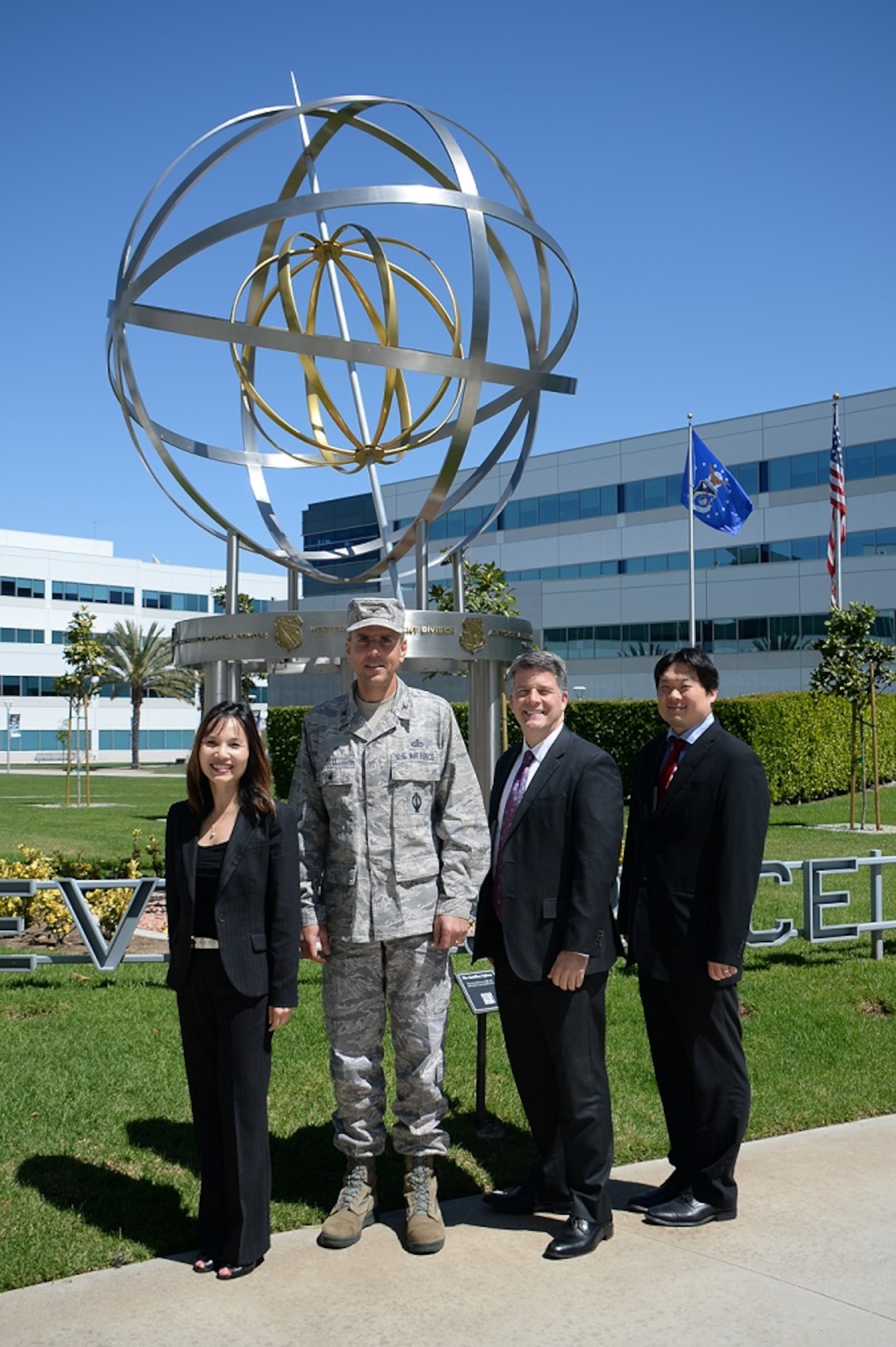 Members of the Space and Missile System Center's Directorate of Financial Management and Comptroller, from left to right, Jenny Tang, SMC/FM deputy director, Col. James Bell, SMC/FM director, John Karns, SMC/FM Cost Estimating Branch chief, and Chinson Yew, SMC Financial Management Cost Division acting chief, stand in front of the Armillary or Space Motif landmark on the grounds of the Schriever Space Complex at Los Angeles Air Force Base in El Segundo, Calif. The Cost Centralization Team recently earned a Special Acts and Services Award as part of the Fiscal Year 2015 Air Force Financial Management and Comptroller awards program for saving over $76 million in budgeted Air Force funding through their cost centralization initiatives. (U.S. Air Force photo/Van De Ha)
