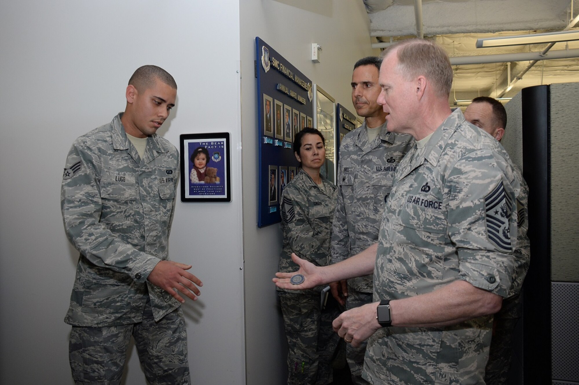 Chief Master Sgt. of the Air Force James A. Cody presents Senior Airman Jeffery Lugo from the Space and Missile Systems Center’s Financial Management Directorate with his CMSAF Challenge Coin as Col James Bell, SMC/FM director looks on during a visit to Los Angeles Air Force Base in El Segundo, Calif., March 9-11, 2016. The visit offered active duty and civilian personnel a rare opportunity to directly address the service’s senior enlisted leader regarding the issues facing today’s Airmen. It also gave Chief Cody a chance to view the unique characteristics of Los Angeles AFB and the capabilities the Total Force offers to accomplish the SMC mission. (U.S. Air Force photo/Van De Ha)