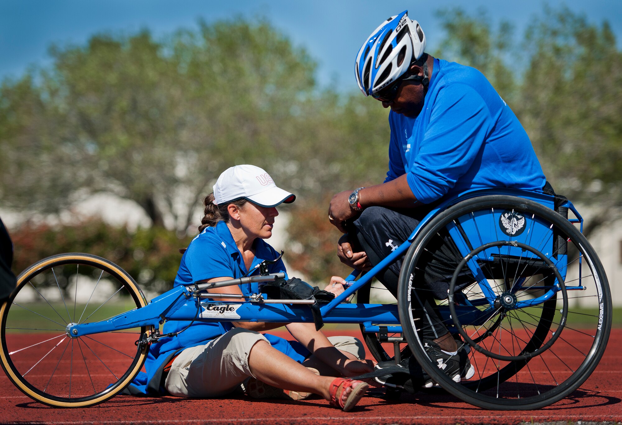 Teresa Skinner, a Warrior Games trainer, makes adjustments to a sports chair for Jamie Womack, a Warrior Games athlete, during an afternoon track and field session at the Air Force team’s training camp at Eglin Air Force Base, Fla., April 4.  The base-hosted, week-long Warrior Games training camp is the last team practice session before the yearly competition in June.  (U.S. Air Force photo/Samuel King Jr.)