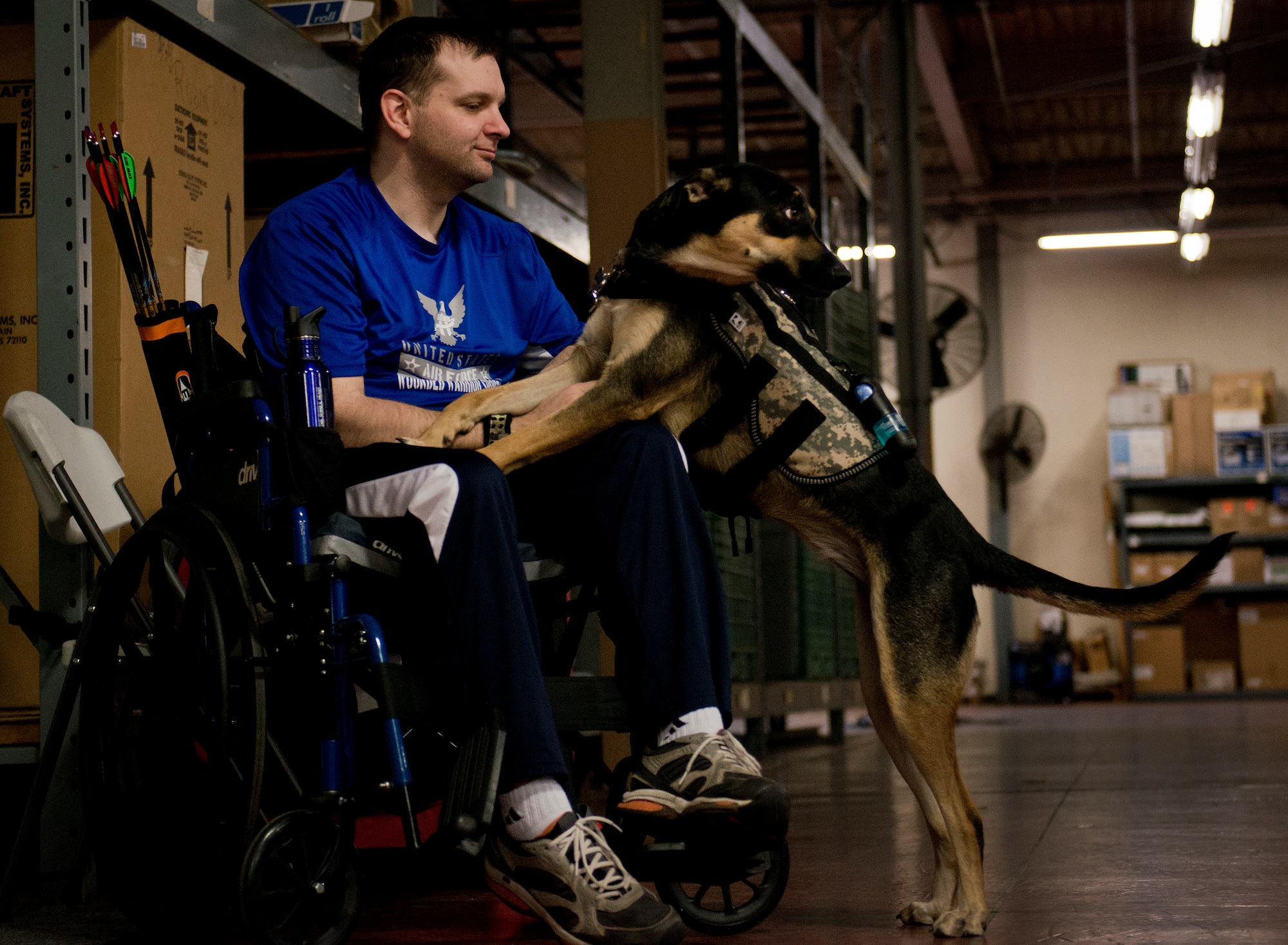 Brian Schaaf, a Warrior Games athlete, pets a service dog during a morning archery session at the Air Force team’s training camp at Eglin Air Force Base, Fla., April 4.  The base-hosted, week-long Warrior Games training camp is the last team practice session before the yearly competition in June.  (U.S. Air Force photo/Samuel King Jr.)