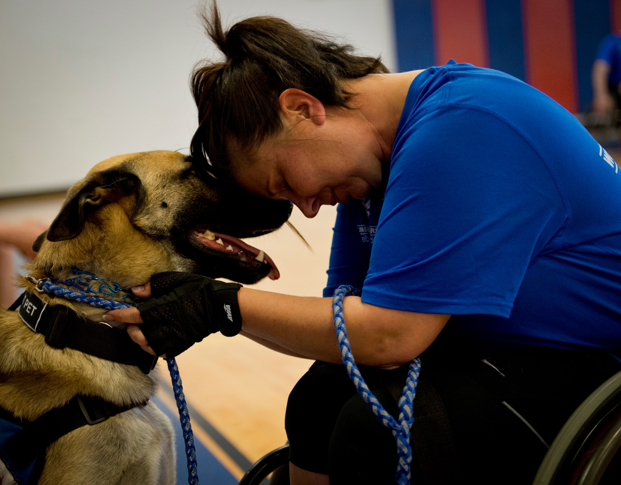 Lisa Hodgden, a Warrior Care mentor, and her service dog, Boston, share a moment during a wheelchair basketball session at the adaptive sports camp at Eglin Air Force Base, Fla., April 4.  The base hosts the week-long Wound Warrior CARE event that helps recovering wounded, ill and injured military members through specific hand-on rehabilitative training.  (U.S. Air Force photo/Samuel King Jr.)