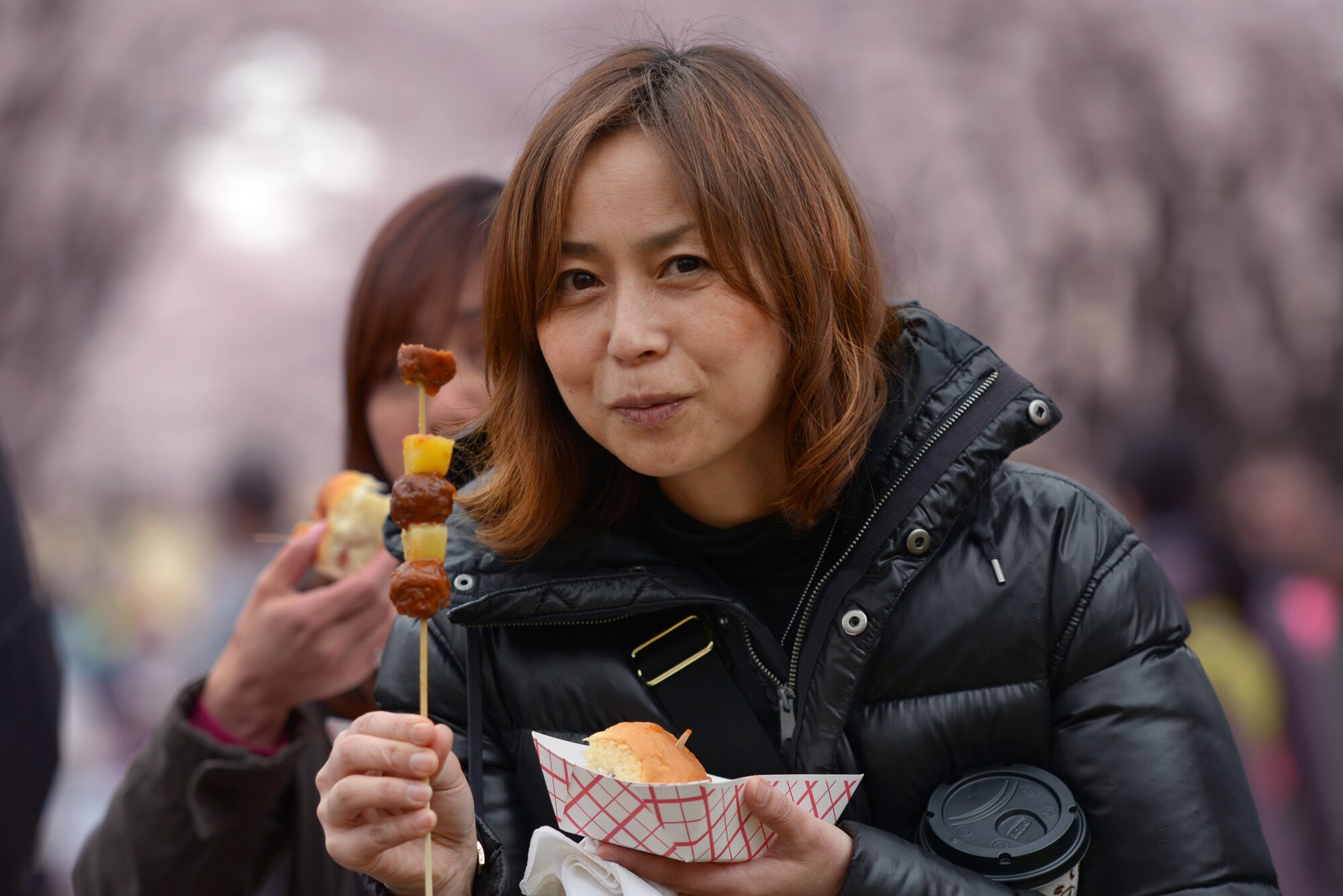 Yuko Hoei eats lunch from the Sons of Hawaii food booth during the Sakura Spring Festival at Yokota Air Base, Japan, April 2, 2016. The festival consisted of band performances, dancers, Taiko drummers and food booths, offering a chance for Japanese citizens to experience American culture within the base’s perimeter. Approximately 4,000 people from local communities attended the event to celebrate the coming of spring. (U.S. Air Force photo by Staff Sgt. Cody H. Ramirez/Released)