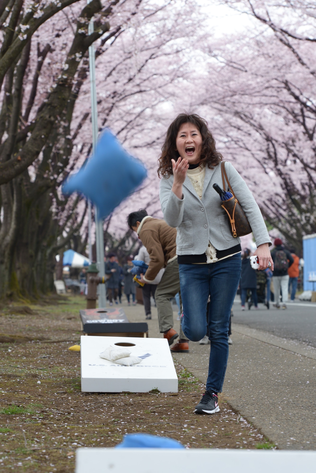 A woman throws a Cornhole bean bag during the Sakura Spring Festival at Yokota Air Base, Japan, April 2, 2016. The festival consisted of band performances, dancers, Taiko drummers and food booths, offering a chance for Japanese citizens to experience American culture within the base’s perimeter. Approximately 5,000 people attended the event to celebrate the coming of spring. (U.S. Air Force photo by Staff Sgt. Cody H. Ramirez/Released)