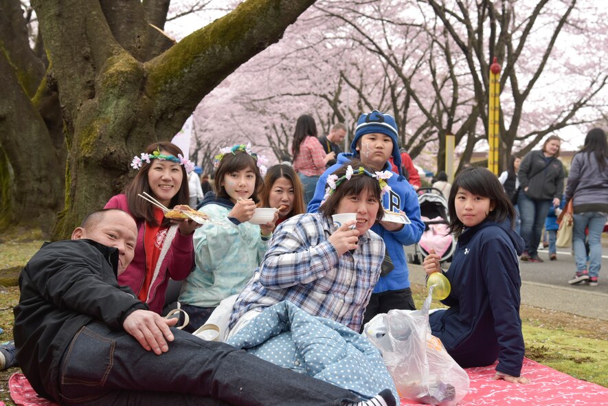 Festival attendees picnic under cheery blossom trees at Yokota Air Base, Japan, April 2, 2016, during the Sakura Spring Festival. The festival consisted of band performances, dancers, Taiko drummers and food booths, offering a chance for Japanese citizens to experience American culture within the base’s perimeter. Approximately 5,000 visitors attended the event to celebrate the coming of spring.  (U.S. Air Force photo by Machiko Imai/Released)