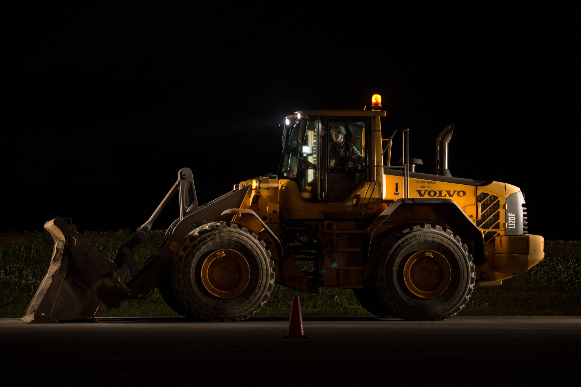 A U.S. Air Force Airman from the 18th Civil Engineer Squadron operates heavy equipment during a nighttime airfield damage repair contingency exercise at the Silver Flag training site April 5, 2016, on Kadena Air Base, Japan. Day or night, the 18th CES ensures continuous airfield operational capability by leveling craters, establishing mobile aircraft arrest barriers, marking boundaries, and setting up runway lights. (U.S. Air Force photo by Senior Airman Peter Reft)