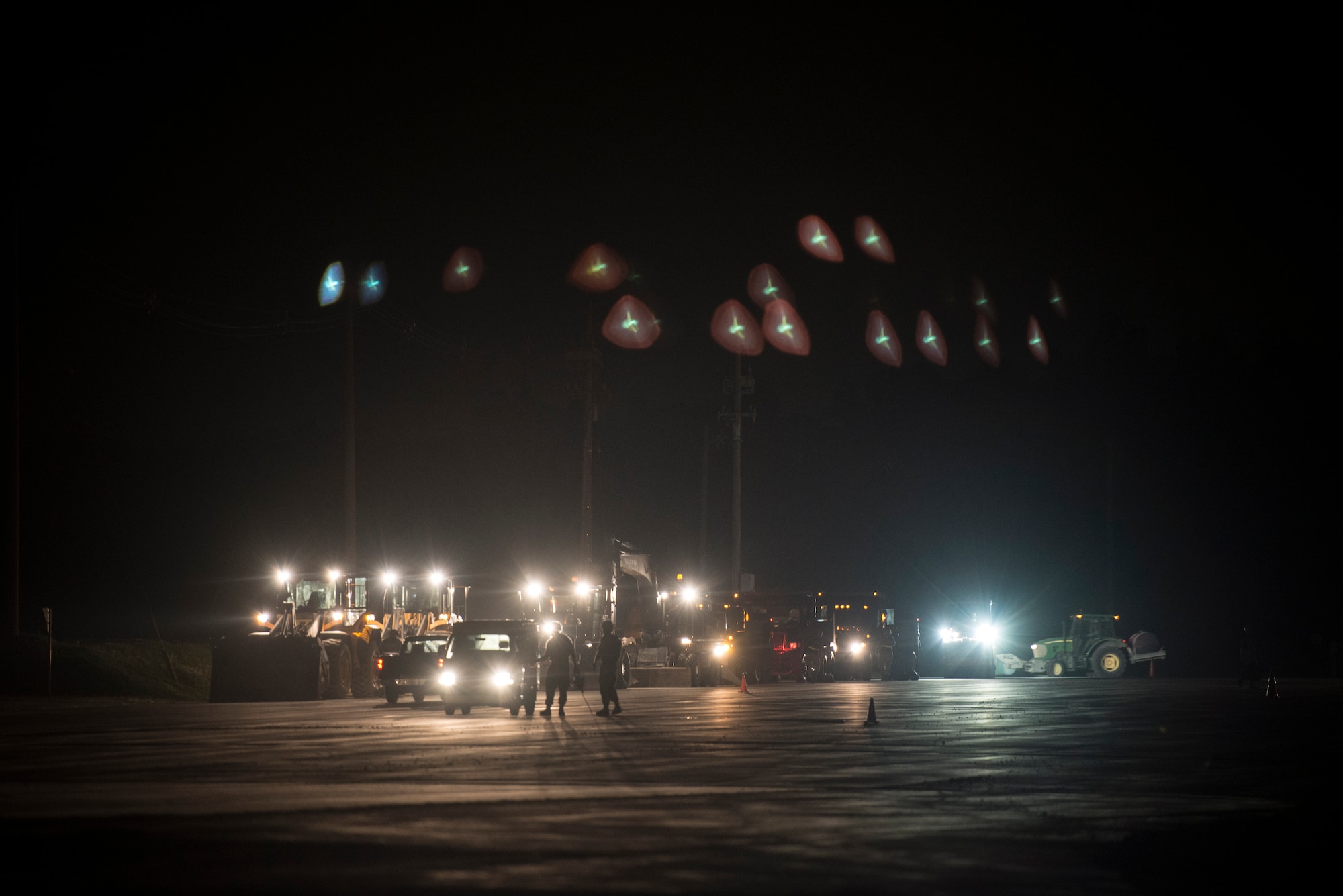 U.S. Air Force Airmen from the 18th Civil Engineer Squadron rally construction equipment during a nighttime airfield damage repair training exercise at the Silver Flag training site April 5, 2016, on Kadena Air Base, Japan. The training enhanced unit readiness for contingency airfield operations in hostile conditions and performing self-aid and buddy care after sustaining casualties. (U.S. Air Force photo by Senior Airman Peter Reft)