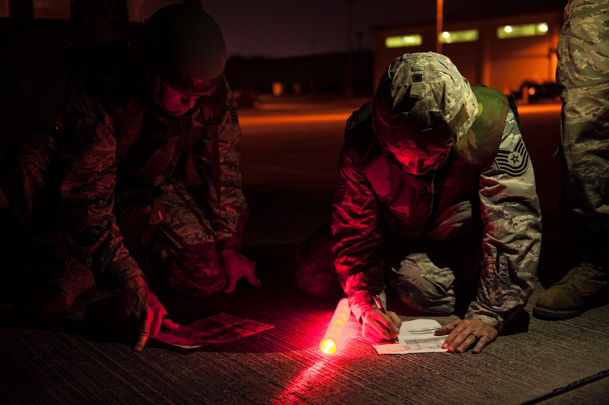 U.S. Air Force Airmen from the 18th Civil Engineer Squadron conduct nighttime airfield damage repair training at the Silver Flag training site April 5, 2016, on Kadena Air Base, Japan. The 18th CES plays an integral role as a fast response repair force by reestablishing damaged runways in order to maintain aircraft combat and logistical capabilities. (U.S. Air Force photo by Senior Airman Peter Reft)