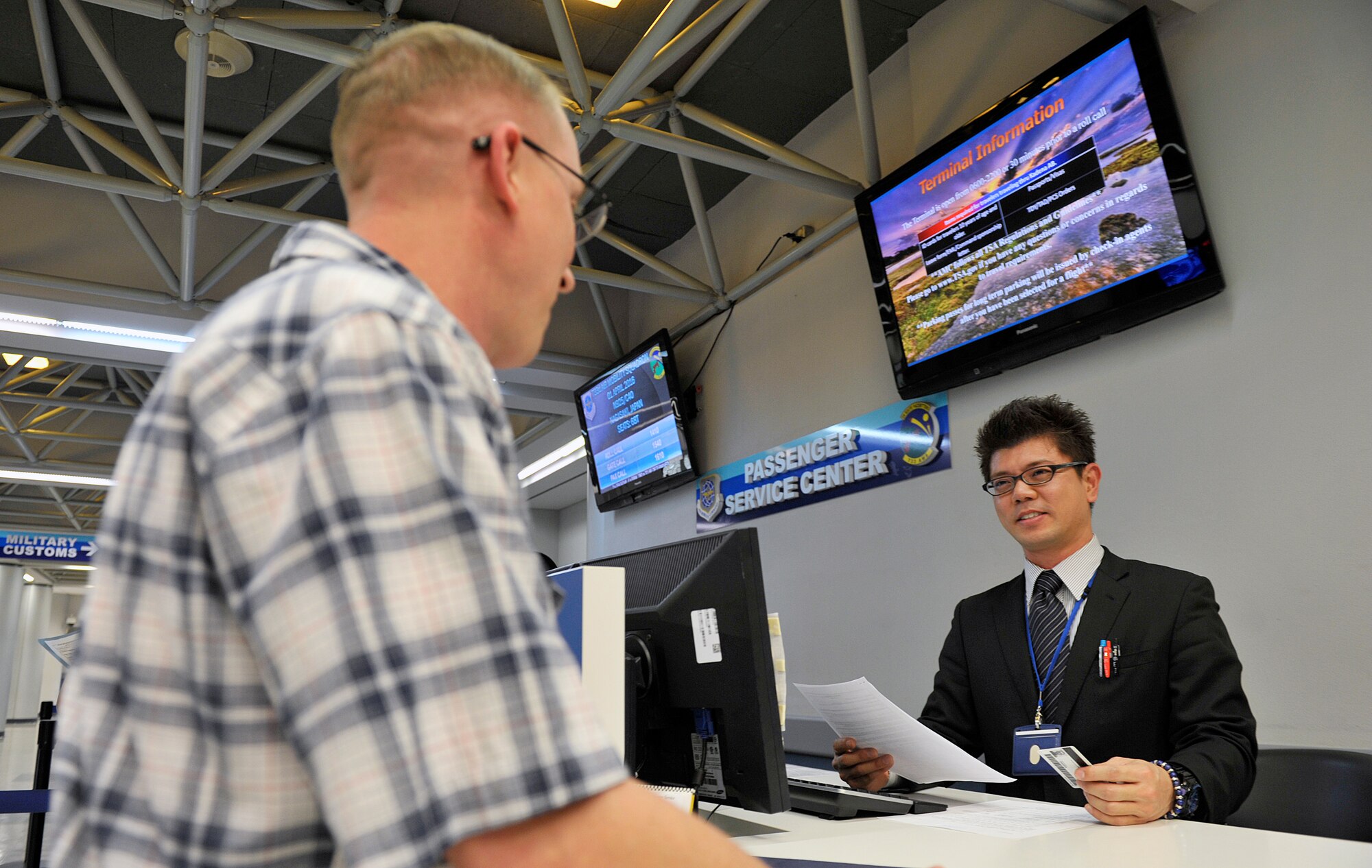 Tomokazu Arakaki, 733rd Air Mobility Squadron passenger service agent, checks a customer's information for the Space-A program at the 733rd AMS Passenger Terminal, April 1, 2016, at Kadena Air Base, Japan. Arakaki said, he loves the moment when he is able to help customers with their requests. (U.S. Air Force photo by Naoto Anazawa)

