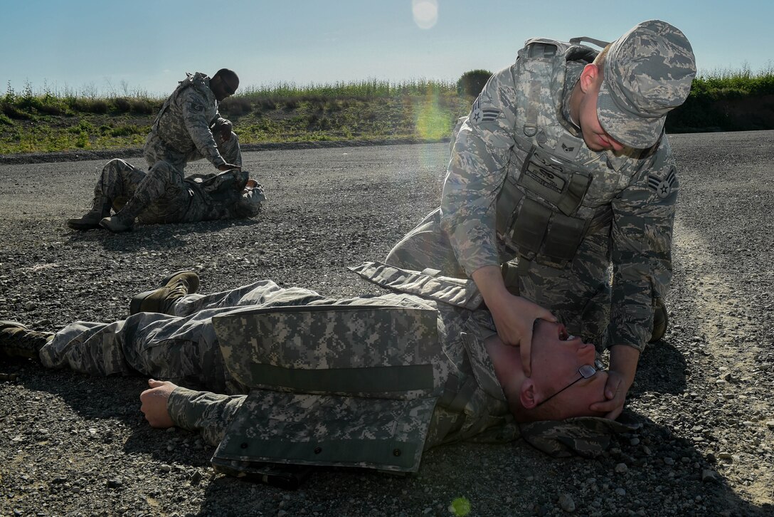 Senior Airman Jacob Burrell performs the head tilt-chin-lift technique to Senior Airman Scott Allen, both 921st Contingency Response Squadron Air Transportation Flight during self-aid and buddy care during field craft training April 1, 2016, at Travis Air Force Base, California. The five day training course was designed to improve how contingency response Airmen are trained in air base opening combat skills. (U.S. Air Force photo by Staff  Sgt. Robert  Hicks/Released) 