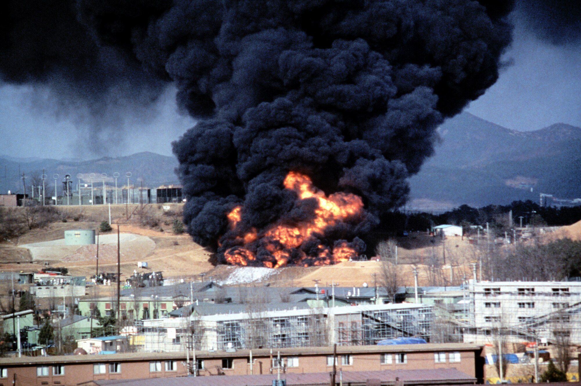 Smoke and flames billow from a 40,000-gallon fuel tank after an explosion at Osan Air Base, Republic of Korea, April 5, 1986. Thirty years after the explosion, the 51st Logistics Readiness Squadron performed a ceremony to honor the 16 individuals who lost their lives. (Courtesy Photo)