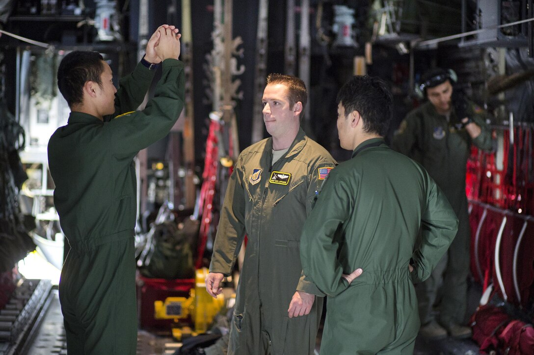 U.S. Air Force Master Sgt. Richard LaFrance, center, talks with Japanese air force loadmasters while aboard a C-130 Hercules aircraft during an annual Non-Commission Officer exchange program at Yokota Air Base, Japan, March 23, 2016. LaFrance is a loadmaster assigned to the 36th Airlift Squadron. Air Force photo by Osakabe Yasuo
