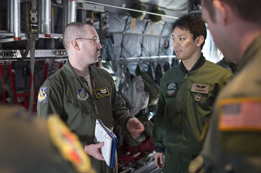 U.S. Air Force Maj. Adam Boyd, left, talks with Japanese Air Force Tech. Sgt. Suguru Yahata after a pre-flight briefing at Yokota Air Base, Japan, March 23, 2016. Boyd is a pilot and chief of group plans and program assigned to the 374th Operations Group and Yahata is a loadmaster assigned to the Special Airlift Group B747. Air Force photo by Osakabe Yasuo