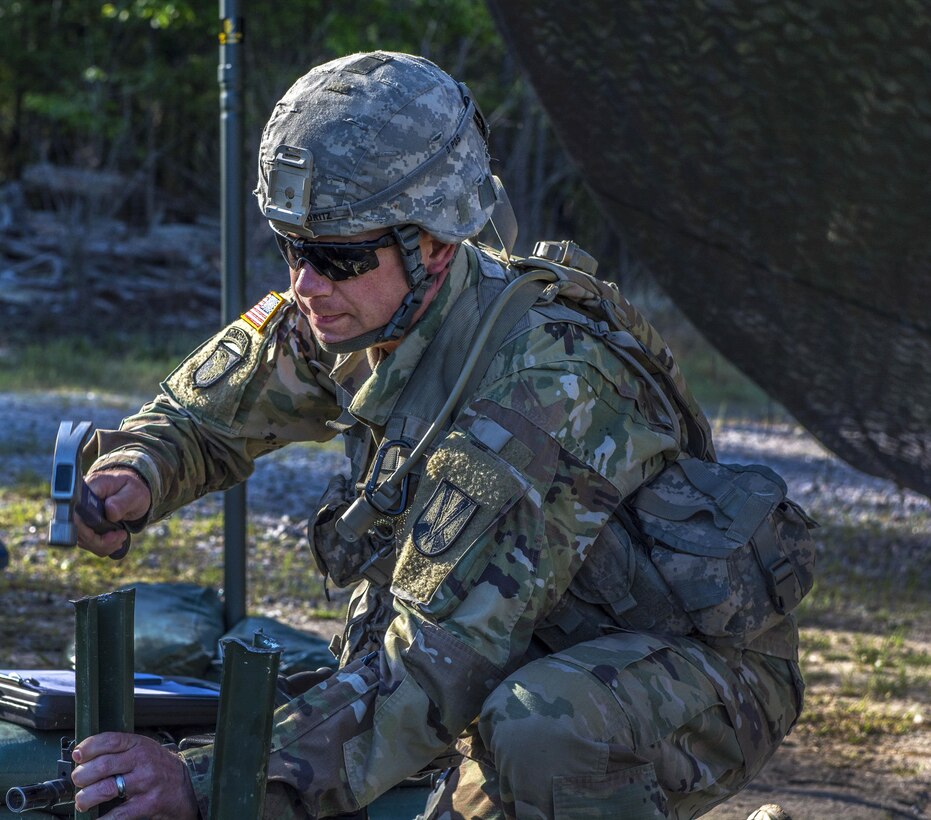 A soldier pounds in metal stakes on a range during the Expert Infantryman Badge qualification at Fort Jackson, S.C., March 30, 2016. Army photo by Sgt. 1st Class Brian Hamilton