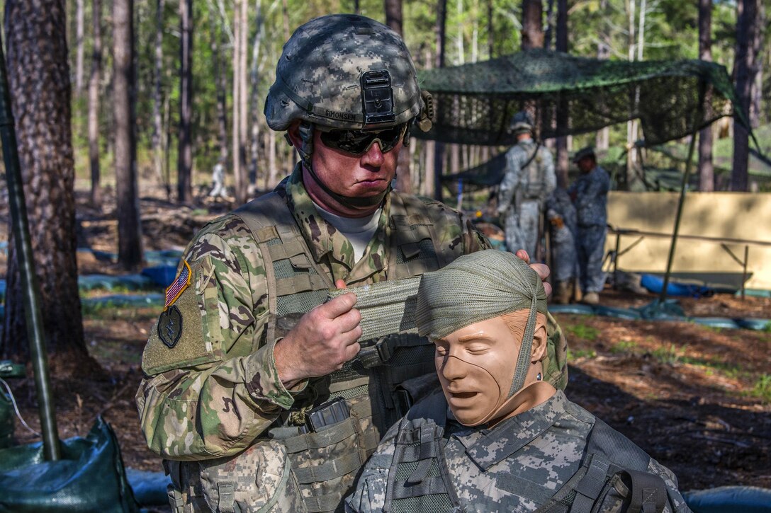A soldier applies a bandage to a mannequin during the field medical testing part of the Expert Infantryman Badge qualification at Fort Jackson, S.C., March 30, 2016. Army photo by Sgt. 1st Class Brian Hamilton