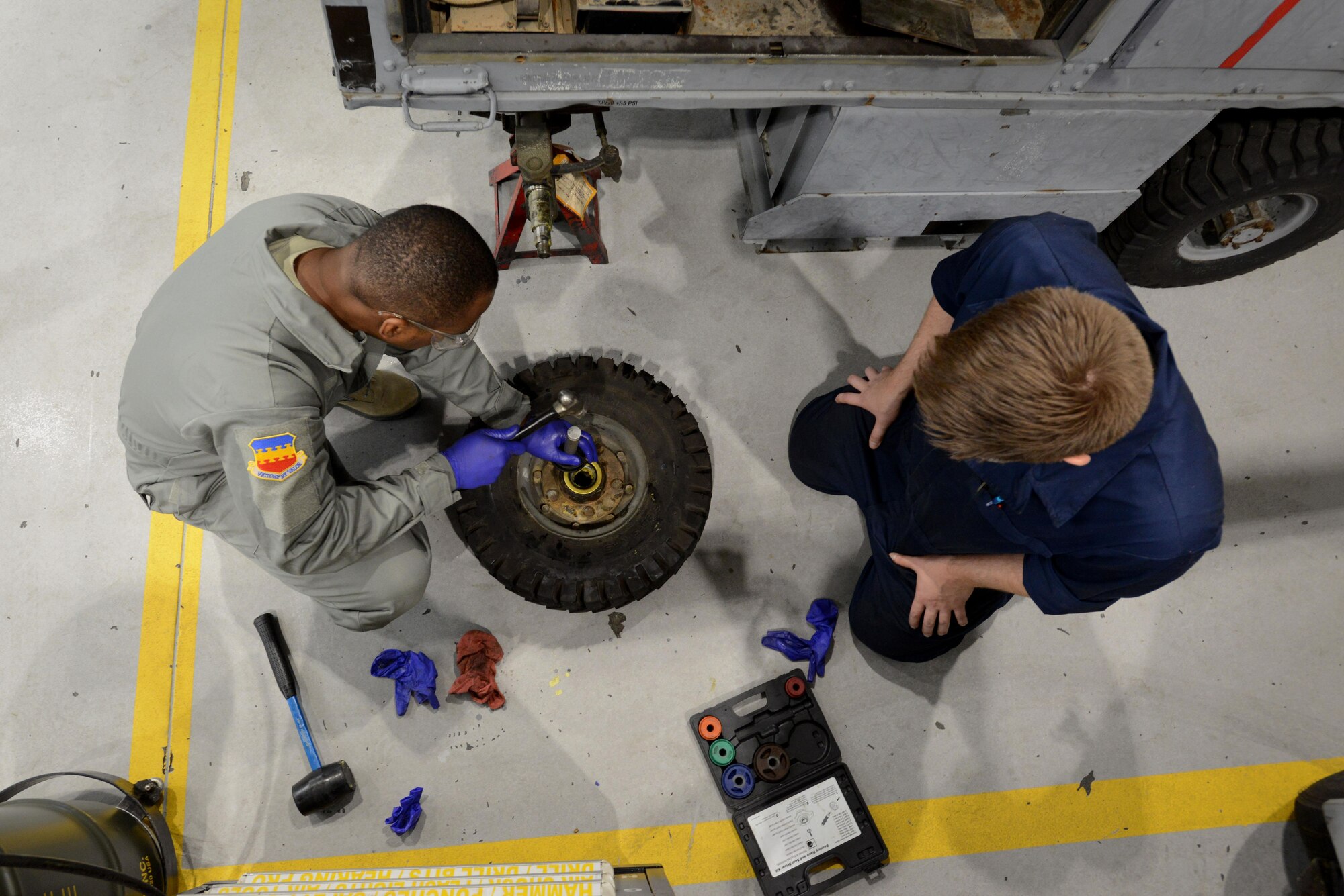 U.S. Air Force Chief Master Sgt. Christopher McKinney, 20th Fighter Wing command chief, replaces the bearings in the tire of an A/M32A-60 generator while Airman 1st Class Kristofer Kabalan, 20th Equipment Maintenance Squadron aerospace ground equipment apprentice, observes at Shaw Air Force Base, S.C., March 29, 2016. Kabalan taught McKinney how to remove, clean, and replace the bearings of the tire during Chief’s visit to learn about the AGE mission. (U.S. Air Force photo by Airman 1st Class Kelsey Tucker)