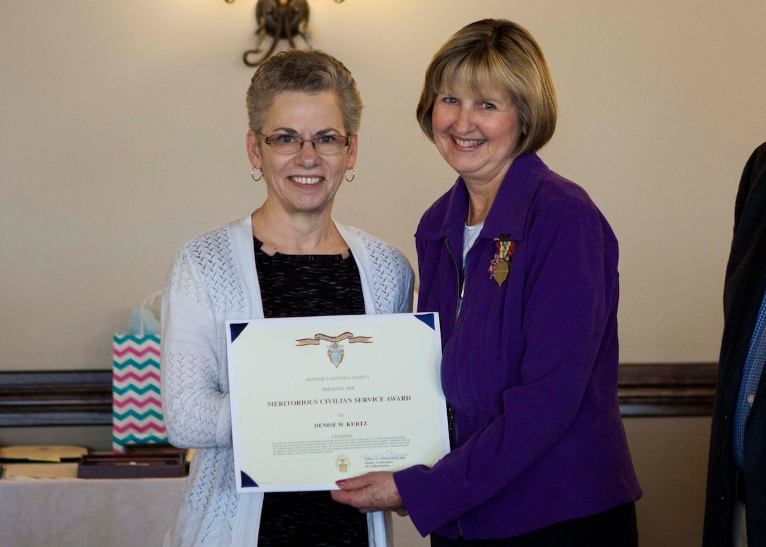 DLA Distribution deputy commander Twila Gonzales, Senior Executive Service, presents Denise Kurtz the DLA Meritorious Civilian Service award at her retirement.  