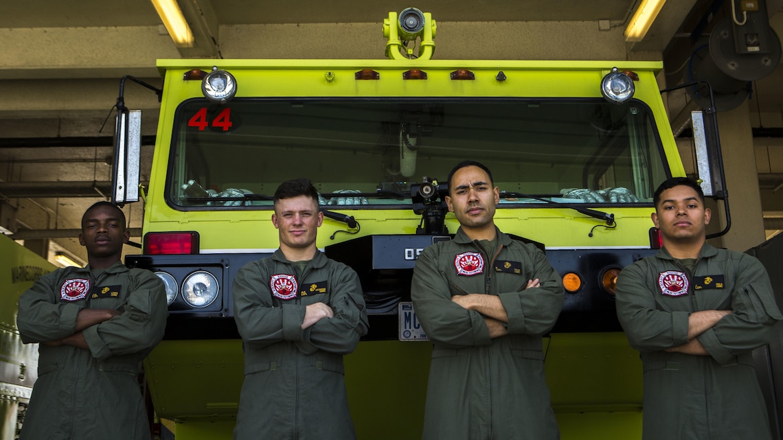 Lance Cpl. Jeremie Lewis, Lance Cpl. Quinn Beckens, Lance Cpl. Rodrigo Cruzvera and Lance Cpl. Javier Avila Jr. pose for a photo in front of their fire truck April 1, 2016. The Marines are aircraft rescue and firefighting Marines with Headquarters and Headquarters Squadron, Marine Corps Air Station Futenma, Marine Corps Installations Pacific. 
