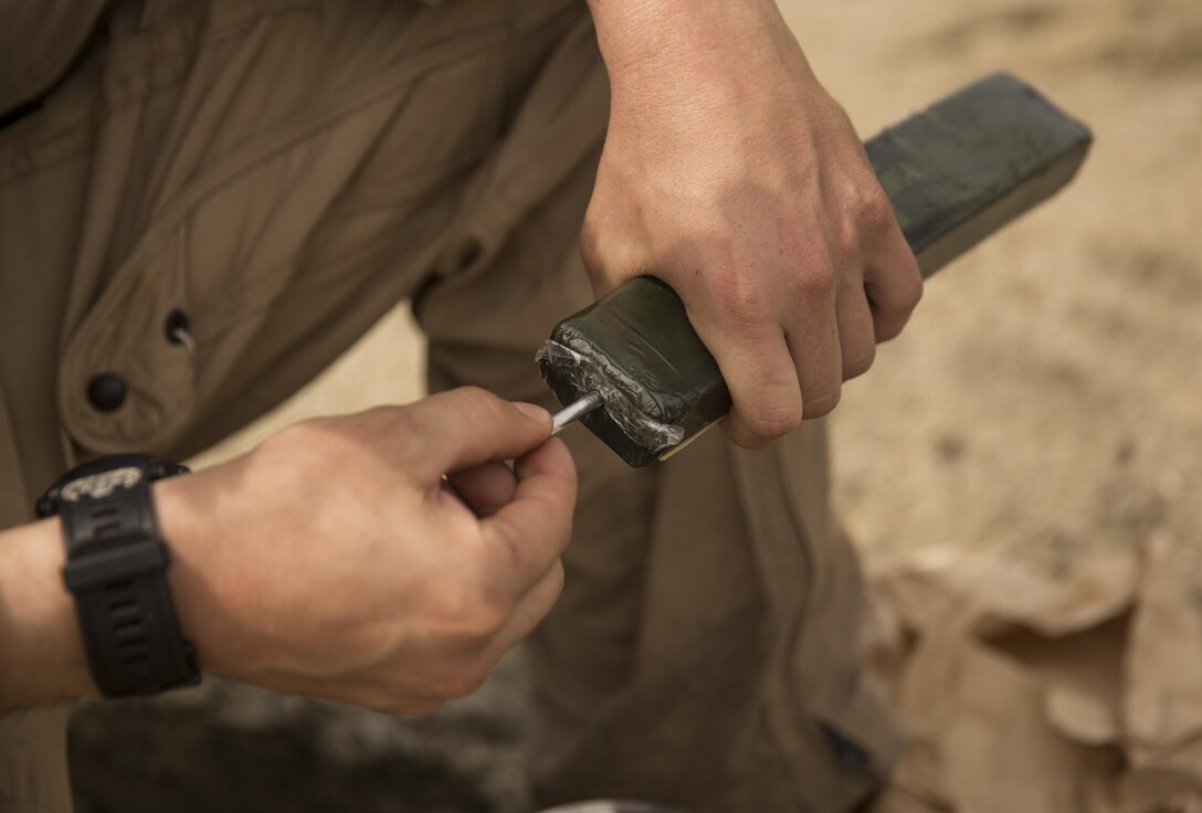 U.S. Marines with Explosive Ordinance Disposal Company, 8th Engineer Support Battalion prime an M112 demolition charge during a clean-up shot aboard Camp Lejeune, N.C., April 1, 2016. Days prior to the clean-up shot, the Marines used the Thermally Controlled Explosive Removal System to safely remove the trinitrotoluene charge, commonly known as TNT, from the 155mm artillery round. The shells will later be used as displays to aid in teaching students about the characteristics of the round. (U.S. Marine Corps photo by Cpl. Justin T. Updegraff/ Released)